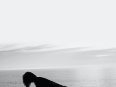 A person standing on the beach in front of the ocean.