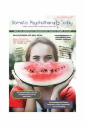 A woman holding up a watermelon slice in front of her face.